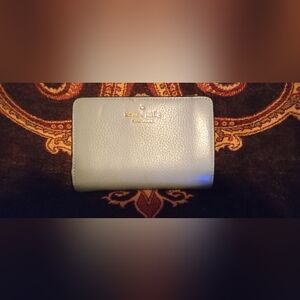 kate spade pebble leather compact wallet in pale blue with gold logo